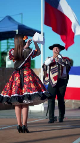 Presentation of a couple of huasos dancing Chilean cueca outdoors