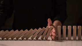 4K slow-motion domino sequence stopped by a hand from right to left, demonstrating control and risk management strategies.
 - Powered by Shutterstock - Get 15% off with code: PIKWIZARD15