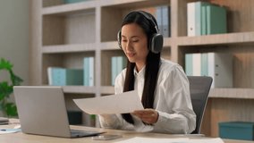 Asian Chinese woman female office worker girl Japanese Korean businesswoman teacher tutor work in wireless headphones talking online laptop video call business meeting discuss report document indoors - Powered by Shutterstock - Get 15% off with code: PIKWIZARD15