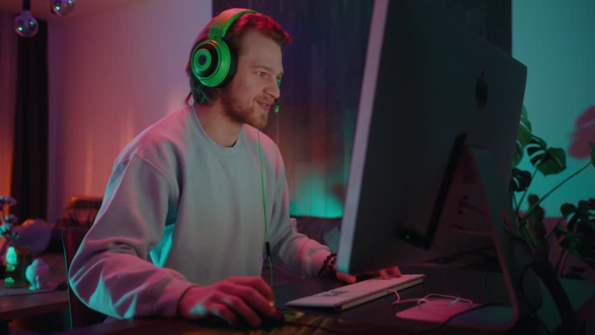 Dedicated gamer deeply focused on the vibrant screen in a stylish, modern gaming setup