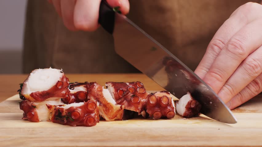 Octopus cooking, chef grill fresh octopus galician style on restaurant kitchen, healthy food, seafood cafe in spain, traditional asian japanese spanish and mediterranean dish.