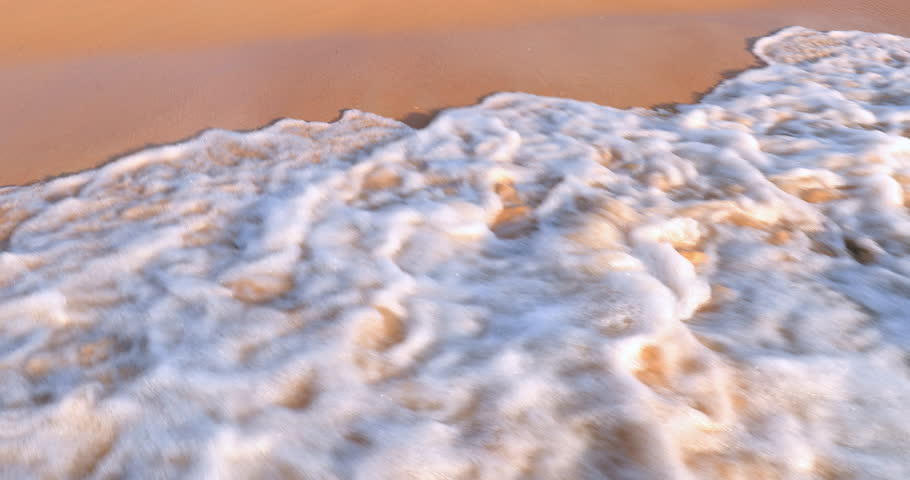 Beach with wave spray and foam relaxing summer background