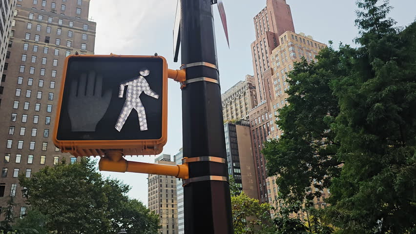 Urban crosswalk signal in New York City, vibrant pedestrian sign among skyscrapers and lush greenery