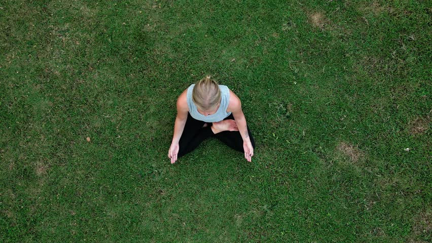 Beautiful Woman Meditating in Relaxing Nature of Yoga Retreat. Bird Eye View on Young Person with Sport Lifestyle Exercising Healthy Body and Mind at Yogi Training. Fitness Leisure and Female Health
