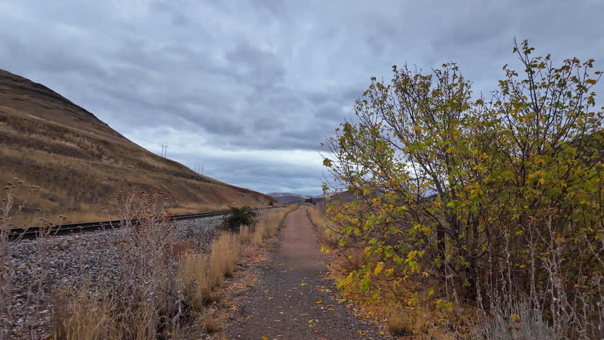 POV walking down the Deer Creek Dam Trail in Utah during Fall on cloudy day.