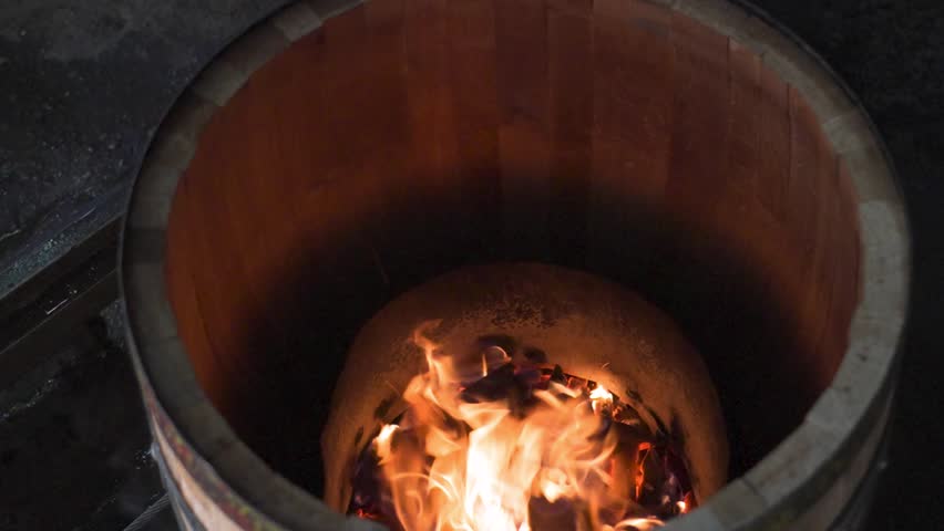 charring the inside of a wooden barrel with fire
