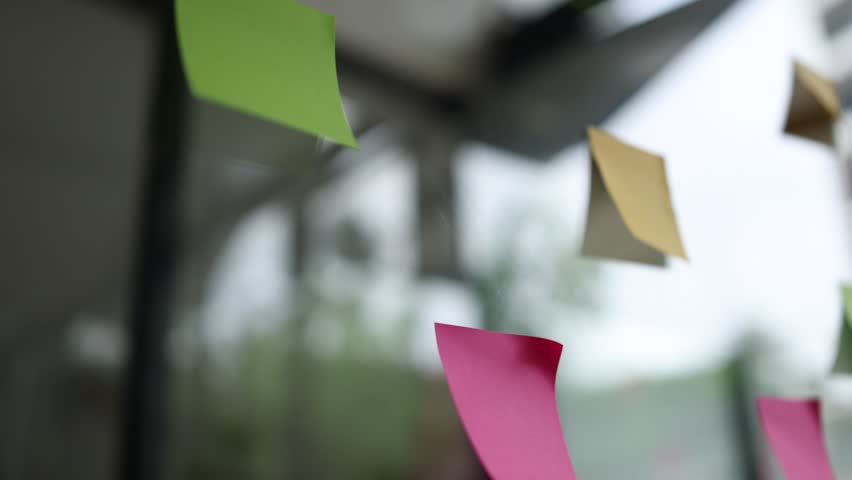 Sticky notes and new ideas on a glass wall, Business brainstorming strategy and new ideas concept.