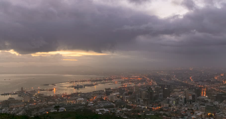 A static Time Lapse shot of sunrise over the City of Cape Town and the Waterfront Harbor, with changing light and dramatic cloud movement.