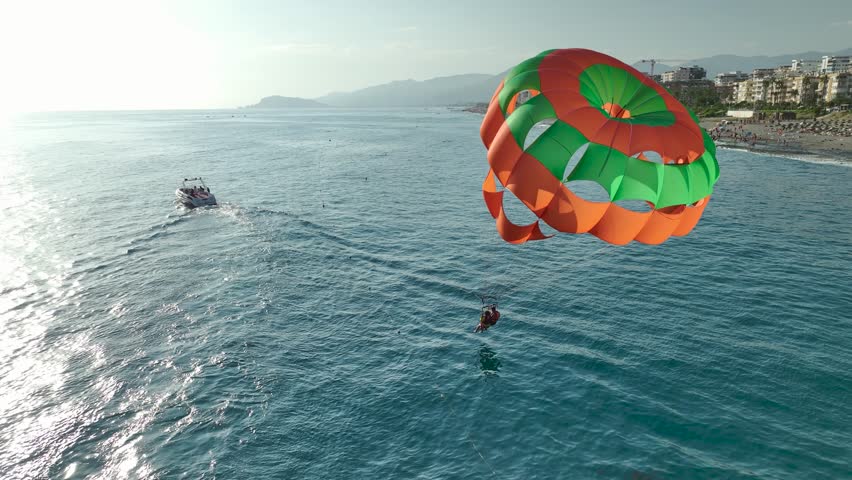 Aerial View 4K: Soaring High - Parasailing at Dusk Over Mediterranean Waters