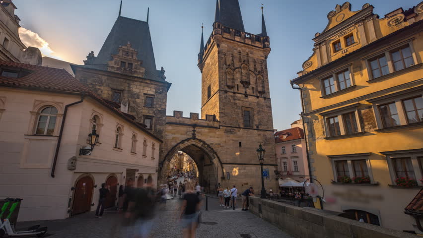 Prague sunset. A view along Charles Bridge in Prague towards the Lesser Quarter in the early morning timelapse hyperlapse. Lots of people can be seen. PRAGUE, CZECH REPUBLIC   