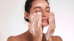 Happy woman gently cleansing her face with a foaming facial cleanser, enjoying her skincare routine. Perfect for promoting skincare, beauty, or wellness products focused on glowing skin.  - Powered by Shutterstock - Get 15% off with code: PIKWIZARD15