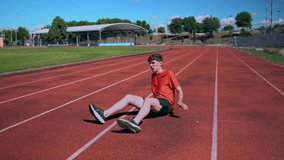Male athlete doing stretching exercises sitting on the track in the stadium - Powered by Shutterstock - Get 15% off with code: PIKWIZARD15