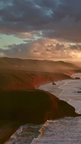 Aerial view on Legzira beach with arched rocks on the Atlantic coast at sunset in Morocco. Vertical video