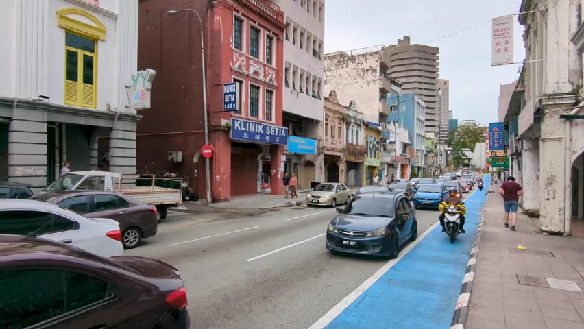Kuala Lumpur , Malaysia - 10 31 2024: Busy street lined with urban buildings, hotels, cafes, shops, with car and motorbike traffic in Little India in capital city of Kuala Lumpur, Malaysia