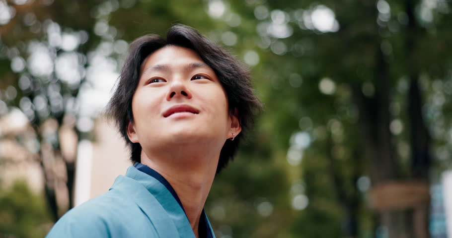 Japanese man, happy and thinking for vision as tourism, outdoor or travel in city street or sidewalk. Male person, idea and planning on vacation, sightseeing or holiday as exchange student with smile