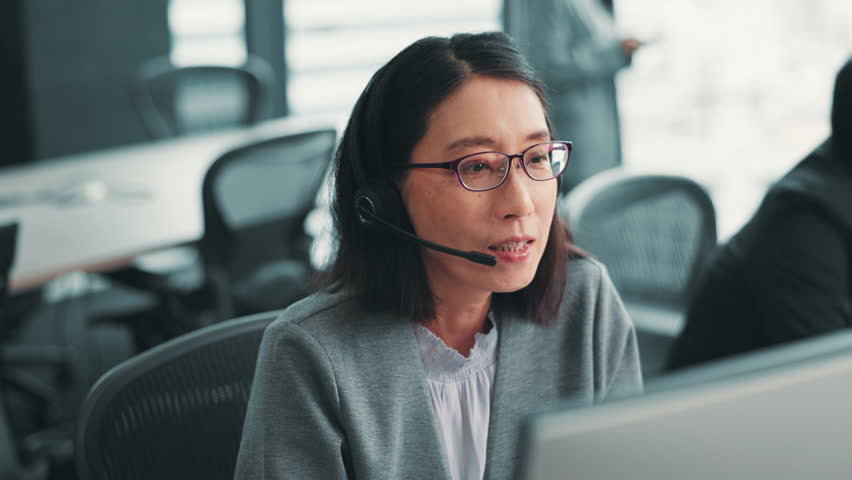 Japanese woman, customer service and conversation with web help, tech and crm support with telemarketing at desk. Sales consultant, online and worker with feedback, call center and headphones for job