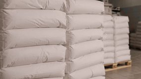 Heavy bags, Warehouse stacks, Pallet organization. Several stacks white bags are neatly organized on wooden pallets within industrial warehouse environment. - Powered by Shutterstock - Get 15% off with code: PIKWIZARD15