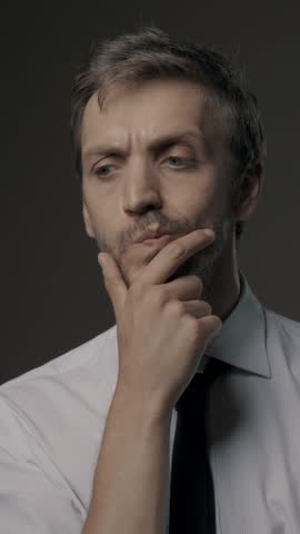 Pensive businessman thinking with hand on chin, problem solving and decisions concept