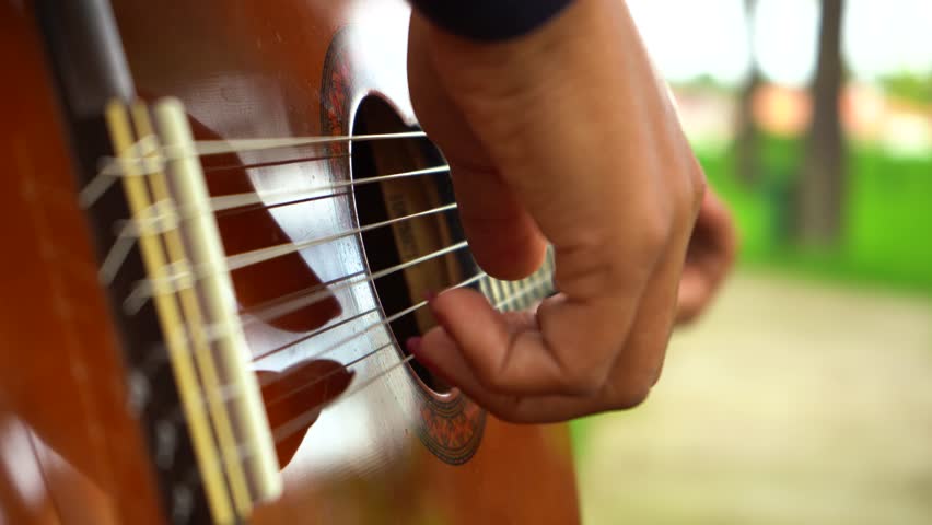 Playing Guitar in Green Park. Guitar Body Close-Up Shot