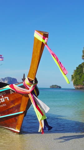 Long tail boat on tropical beach (Pranang beach) and rock, Krabi, Thailand. Vertical video