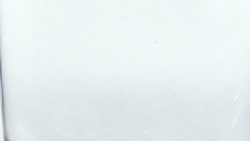 Swirl of black ink mixes clear water in glass. Fluid motion shapes textures. Creativity transformation. Liquid form. Experiment with paint and liquid. White background.