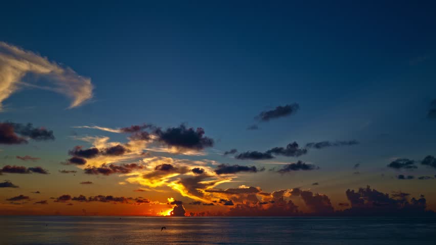 Timelapse Sunset with sun and clouds on blue and orange dramatic sky with sun rays. Night Sky timelapse. Moving clouds at sunset. Evening Clouds. Dusk twilight sky time lapse. Dramatic skies.