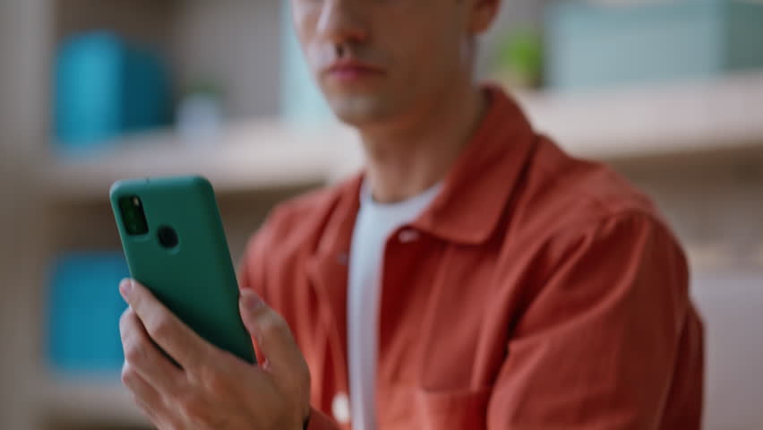 Working manager looking cellphone screen reading message with smile closeup. Busy businessman typing laptop receiving great news on phone. Happy entrepreneur reading smartphone notification in office.