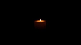 A solitary candle burns steadily, its flame flickering softly as wax melts and drips, casting a warm glow against a deep black background. - Powered by Shutterstock - Get 15% off with code: PIKWIZARD15