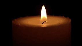 A solitary candle burns steadily, its flame flickering softly as wax melts and drips, casting a warm glow against a deep black background. - Powered by Shutterstock - Get 15% off with code: PIKWIZARD15
