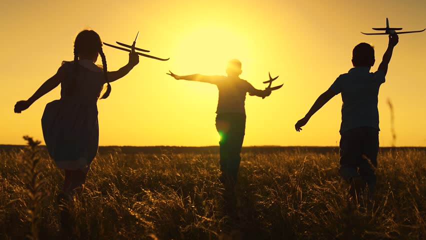 Kids, pilot runs with toy plane across field, fly sky. Children boy play with toy airplane outdoor Silhouette. Future pilot. Child wants to become an astronaut. Kids Friends girl boy dreams of fly sun