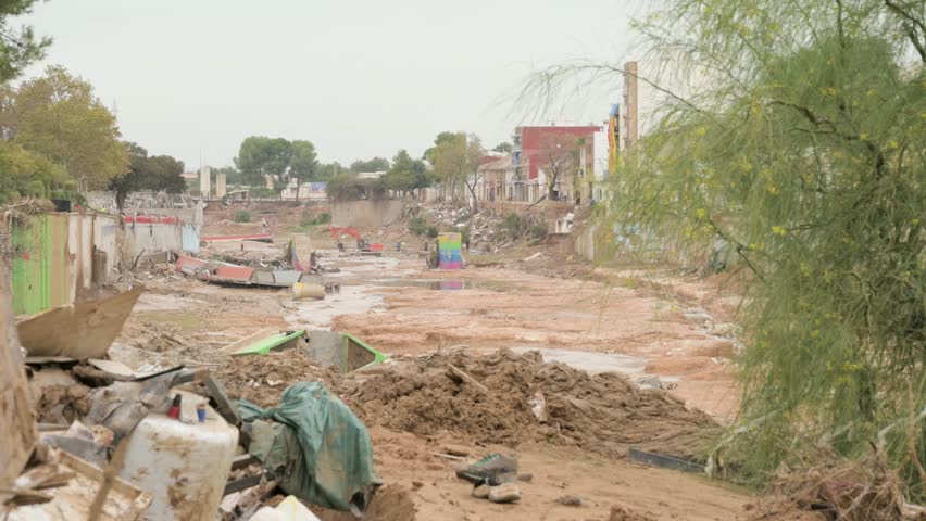 Storm-hit area with debris, ruined buildings, and collapsed bridges in Valencia
