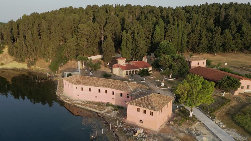 An orbiting view of Zvernec Monastery nestled within the tranquil Narta Lagoon in Albania