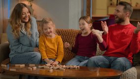 Happy parents children little girls kids playing game wooden blocks build carefree joyful father mother daughters siblings break tower laugh fun at evening home funny holiday together family relations - Powered by Shutterstock - Get 15% off with code: PIKWIZARD15