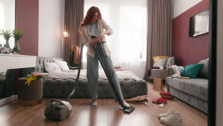 Mess in bedroom home cleaning stressed busy woman girl lady female housewife homeowner vacuum cleaner housekeeping chores multitasking businesswoman clean talk phone write notes stress rush deadline
