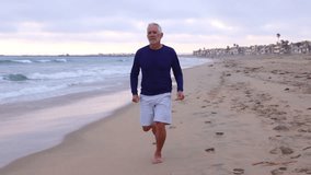 A mature 66 year old man jogging at the beach in Southern California. Slow Motion. - Powered by Shutterstock - Get 15% off with code: PIKWIZARD15