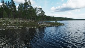 Family enjoying nature at lake Hällsjön in Idre Dalarna Sweden, grilling food on a campfire in a hiking hut. Mother reading a book while a father preparing and sharing meals with their son, drone shot - Powered by Shutterstock - Get 15% off with code: PIKWIZARD15