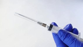 Hands in medical gloves remove cap from syringe needle. Opening syringe. Routine vaccinations for children concept. Vaccination. Sterile medical items. Open syringe needle for injection. Antibiotics. - Powered by Shutterstock - Get 15% off with code: PIKWIZARD15