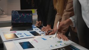 Investors brainstorming, planning, pointing at digital TV screen showing stock market index to analyze stock charts, investing, making profit, trading stock market and currency data in office. - Powered by Shutterstock - Get 15% off with code: PIKWIZARD15