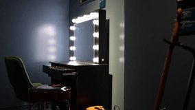 A dressing room setup for a performer, featuring a classic vanity mirror illuminated with bright lights, a green chair, and a Fender-branded stool, creating a backstage ambiance. - Powered by Shutterstock - Get 15% off with code: PIKWIZARD15