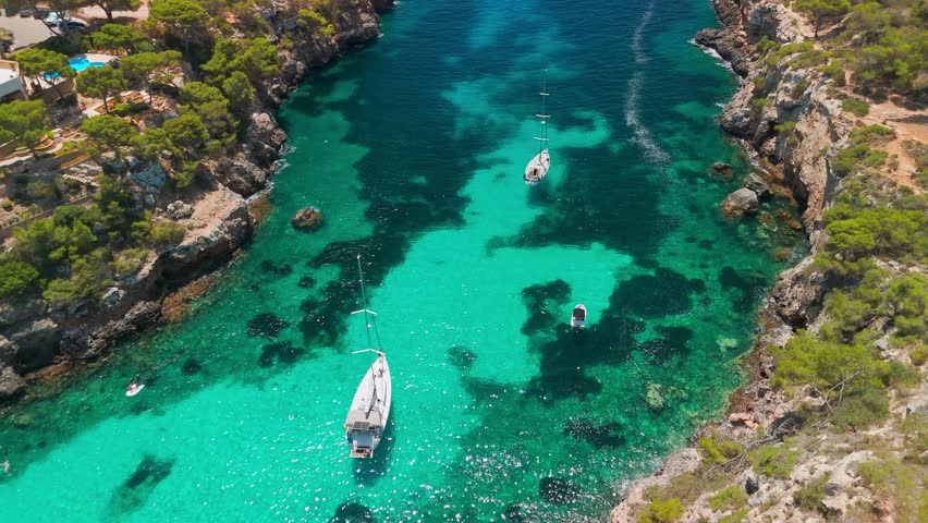 Aerial revealing view of the Bay of Cala Pi in Mallorca, Balearic Islands, Spain. Stunning Mediterranean Sea coast with turquoise water sea bay and white sand beach. Mallorca travel destinations