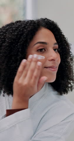 Woman, lotion and skincare in bathroom at house of facial cosmetic, dermatology sunscreen and wellness. Person, apply cream and natural product of self care, morning routine and hydration moisturiser