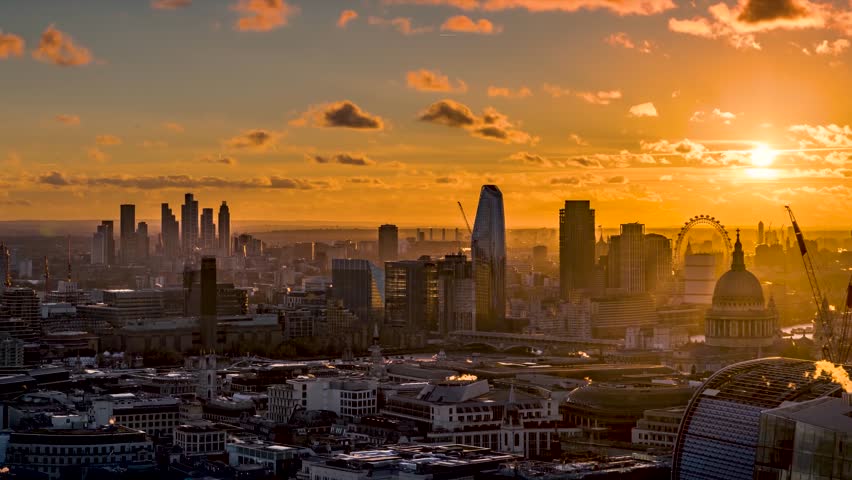 Sunset to night time lapse view of the skyline of central London from Elephant and Castle in the background along the river Thames until Westminster