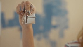 Woman holding house keychain indoors symbolizing new home purchase in a colorful living room setting showcasing celebration and anticipation for new beginnings. - Powered by Shutterstock - Get 15% off with code: PIKWIZARD15