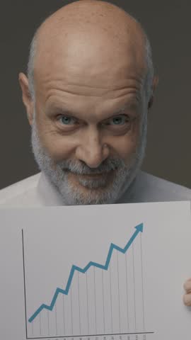 Happy senior businessman showing a successful positive financial chart and smiling at camera