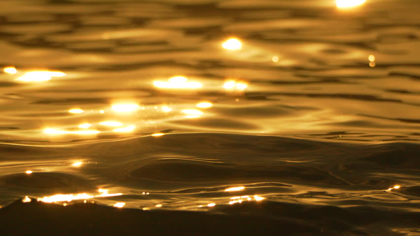 Water Sunset Reflections Golden - Closeup of water surface with shimmering light reflections during sunset.