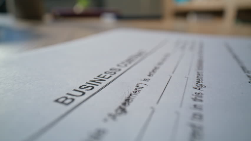 Lawyer hand stamping business deal on desk macro closeup. Unknown business person approving legal agreement at workspace environment dolly shot. Professional business paperwork processing concept.