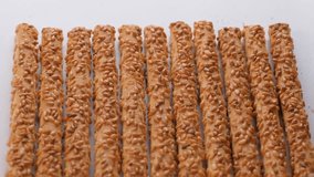 Top view. Crispy pretzel sticks coated with sesame seeds. Breadstick. Slider shot. Shallow depth of field, selective focus. Snack food, bakery, culinary, appetizer contents. 4k - Powered by Shutterstock - Get 15% off with code: PIKWIZARD15