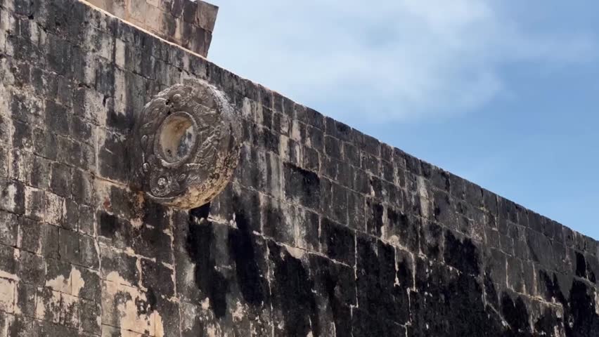 Handheld close-up panning shot of the stone ring at the Great Ball Court in Chichen Itza, Mexico. 4K
