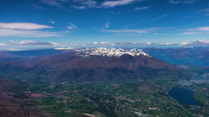 Aerial of a snow peaked Southern Alps in Queenstown, New Zealand on a blue sky day
