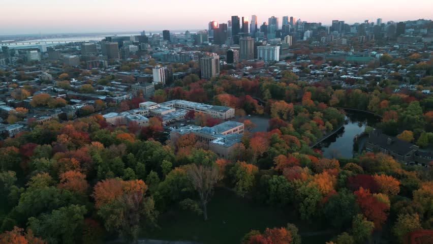 aerial shot revealing Montreal skyline at sunset from parc Lafontaine in le Plateau during fall season, Quebec province, Canada